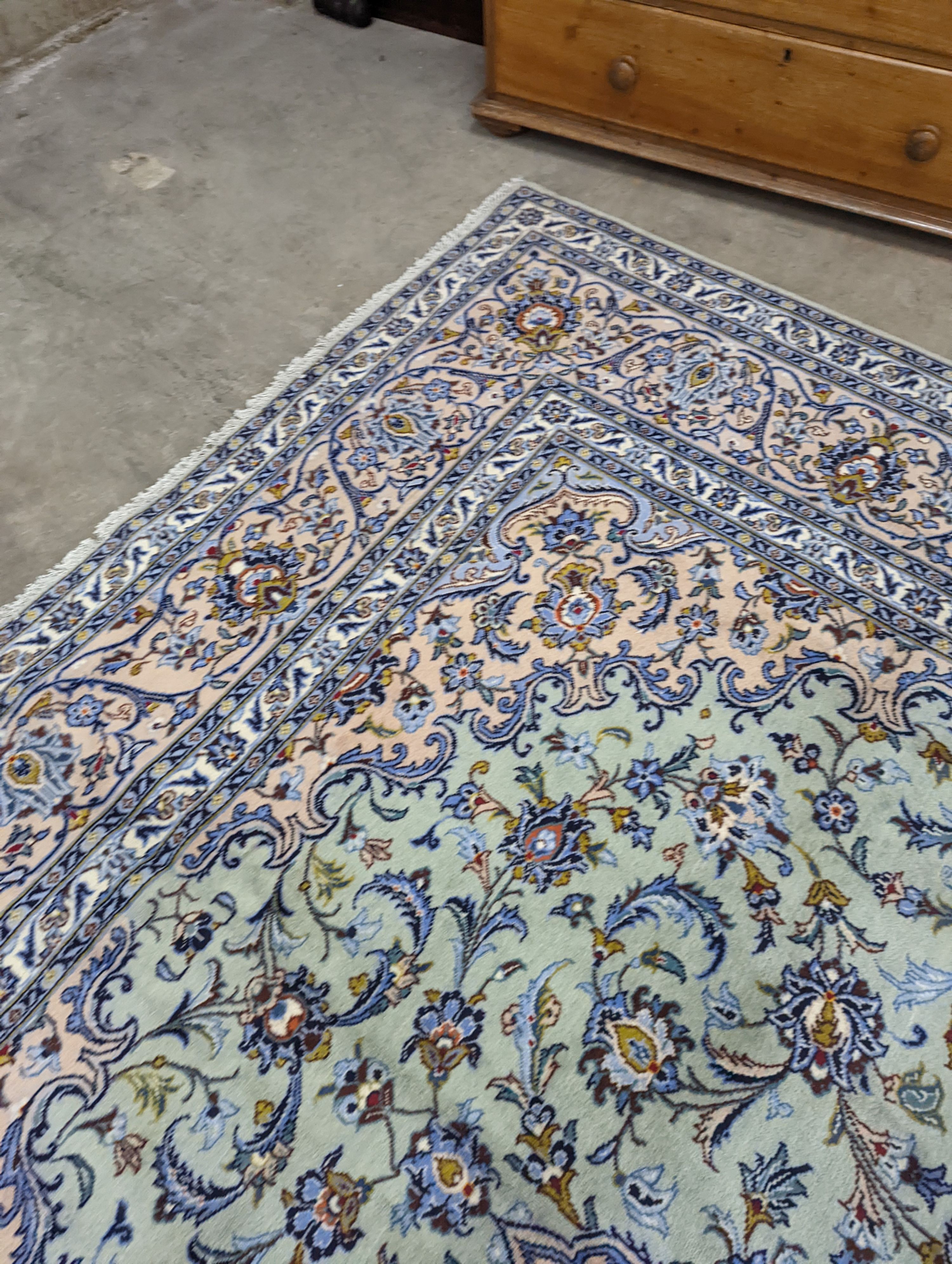 A Kashan pale green ground carpet, 410 x 296cm